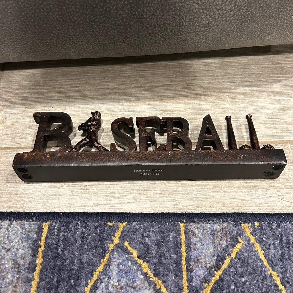 Baseball free standing decoration.  11 5/8” L x 3” H x 1 3/8” W Brown Tones